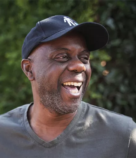 Black man wearing a baseball cap looking to his left