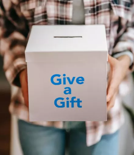Man holding box that says 'Give a Gift'