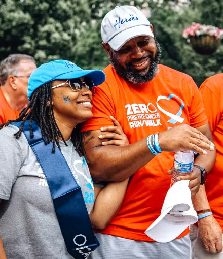 A Black couple with linked arms smiling as they walk at a Run/Walk event