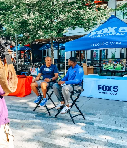 A camera person recording ZERO Champion, Eric Morrow, and a FOX 5 reporter in DC