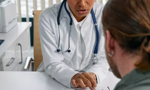 White female doctor reviewing patient's file with a male patient