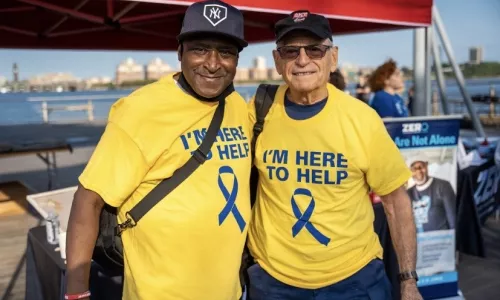 African American and white man in yellow t-shirts volunteering at a ZERO Prostate Cancer event