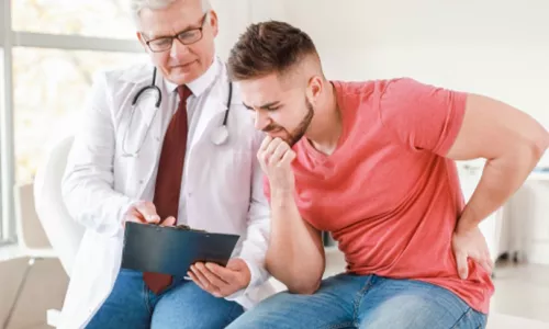 A man sitting next to his doctor looking at a clipboard