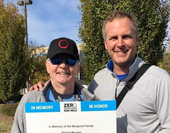 Barry and son Morgan hold up a sign in memory of the Berglund family