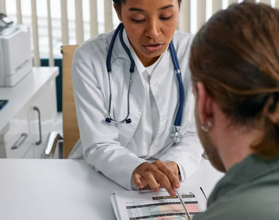 White female doctor reviewing patient's file with a male patient