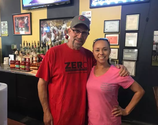 Two friends standing together in a sports bar
