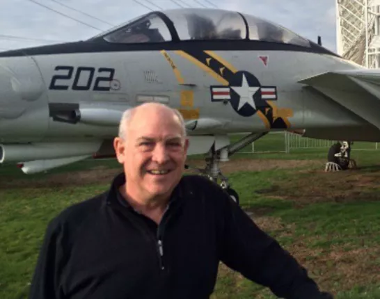 Retired navy veteran standing in front of a Grumman F-14A Tomcat at the Museum of Flight