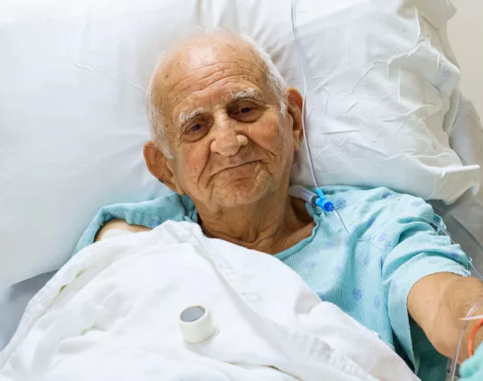 A senior man laying in a hospital bed