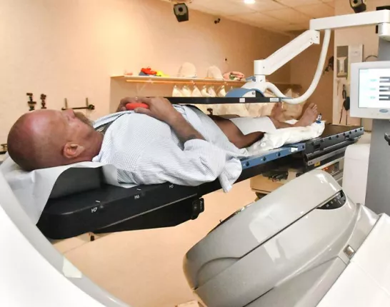 A man laying on a medical table receiving medical treatment
