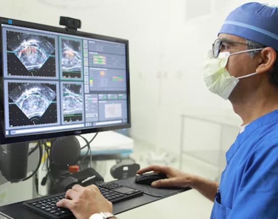 Doctor standing at computer looking at ultrasound images