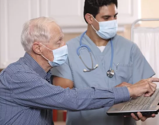 doctors with masks look at laptop