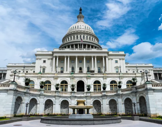 Large united states capital building from the on a very blue and partly cloudy sky day