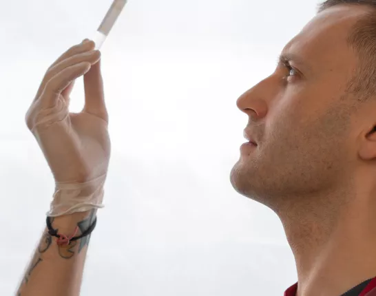 Close-Up Shot of Man Holding a Test Tube