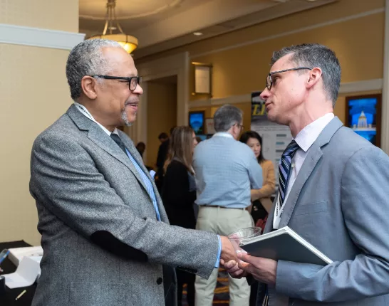 Two men in grey suits shaking hands