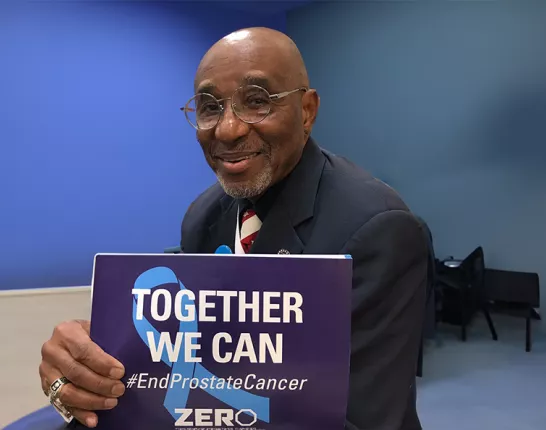 Black man holding a sign that says "Together We Can"