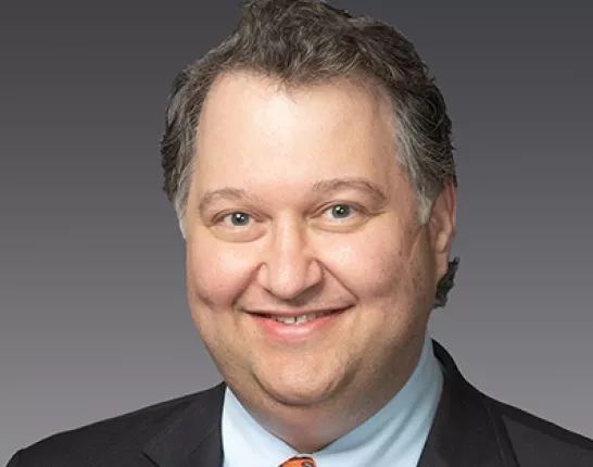 Middle-aged man in a suit smiling at the camera