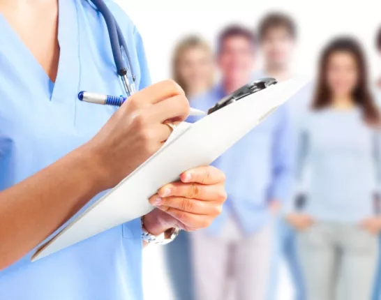 Medical professional holding a chart in front of a group of people