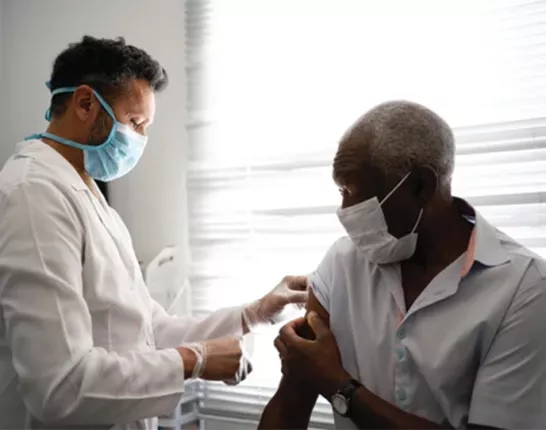 Black man holding up his sleeve for a doctor