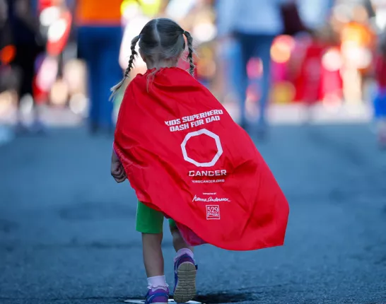 Young girl wearing a superhero cape