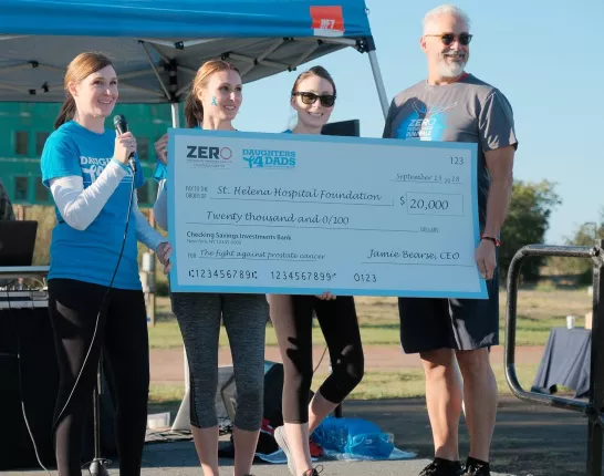 Group of people holding a massive check