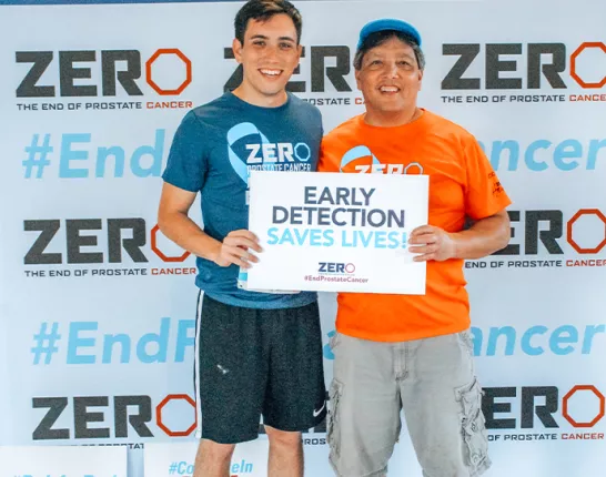 Two men holding a sign that says "Early Detection Saves Lives"