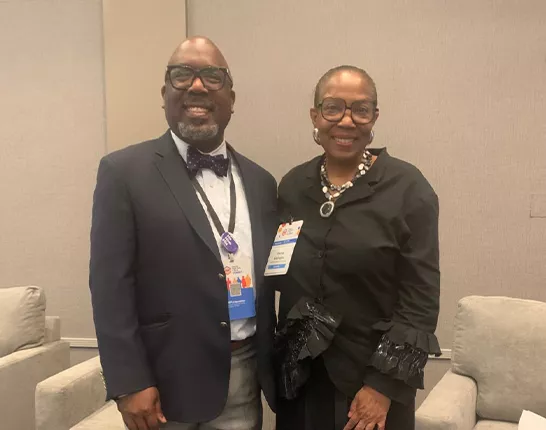 Dr. Reggie Tucker-Seely standing next to a woman at an event