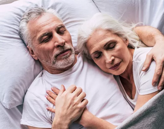 A senior couple cuddling in bed together