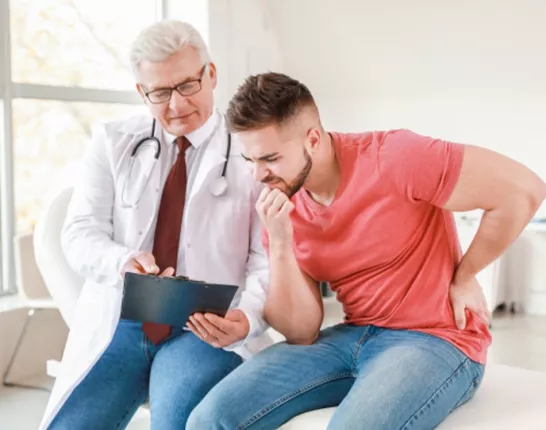 A man sitting next to his doctor looking at a clipboard