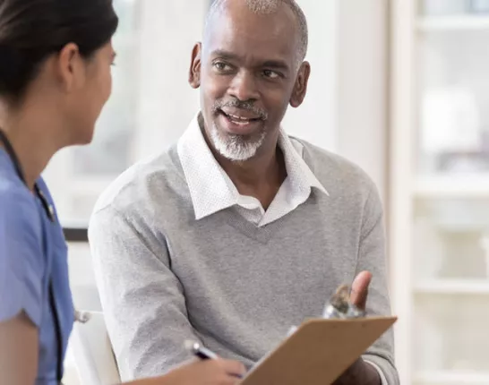 Black male talking to his nurse about health disparities 