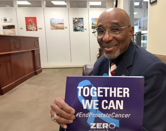Man holding sign that says Together we can END prostate cancer