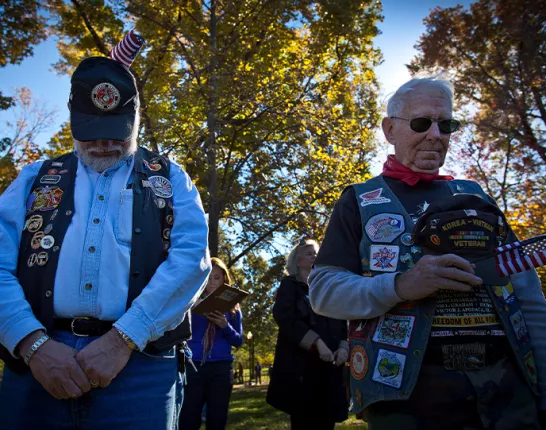 Two veterans with their heads down