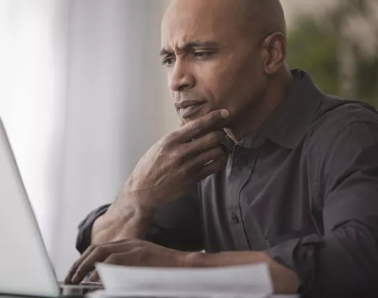 Middle aged black man looking at laptop