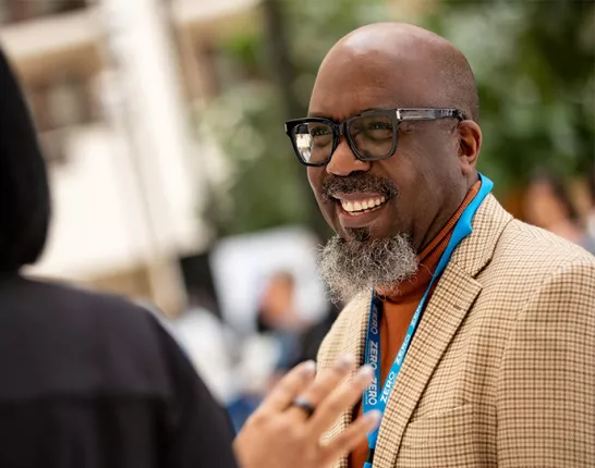 Reggie Tucker-Seely smiling while he talks to another person