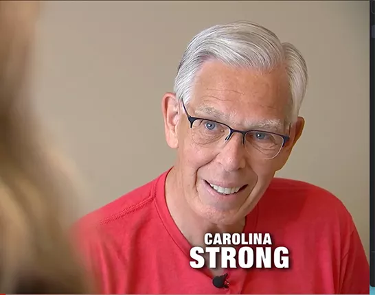 Prostate cancer survivor, Bob Lane, speaking to someone out-of-frame for a news segment called Carolina Strong