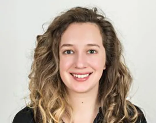 Headshot of a young woman with curly hair—Brianna Abbott, health reporter at the Wall Street Journal