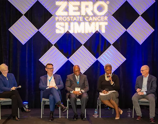 A group of panelists sitting on stage at the Summit