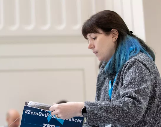 Woman with blue hair highlights showing a brochure to an African American man in suit