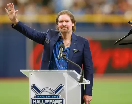 Wade Boggs standing behind a podium that says "Hall of Fame"