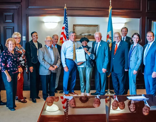 A large group standing in the office of the Delaware governor