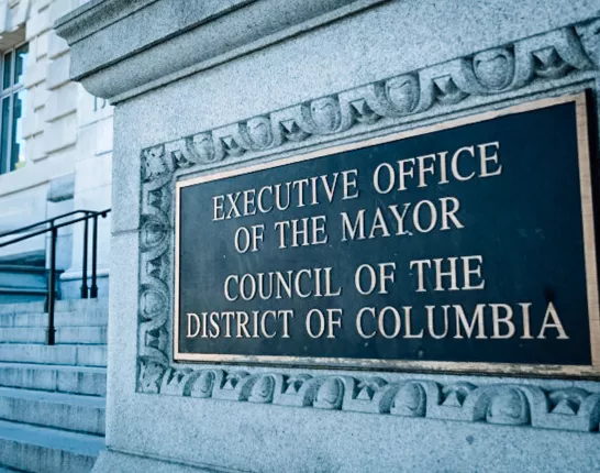 Outdoor sign that says "EXECUTIVE OFFICE OF THE MAYOR COUNCIL OF THE DISTRICT OF COLUMBIA"