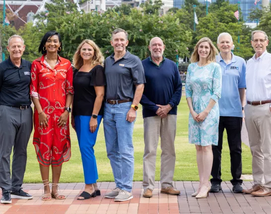 A group of professionals standing outside in a park