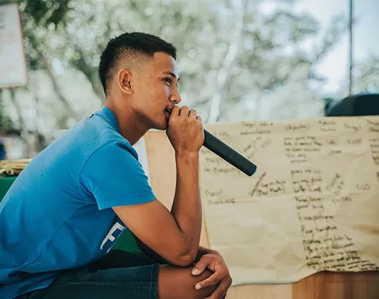 Person sitting down speaking into microphone