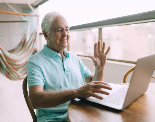 A man waves to the online support group members during a virtual meeting.