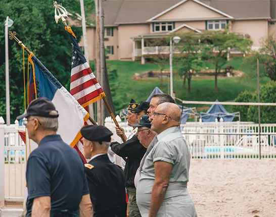 Veterans standing to the left with the American flag