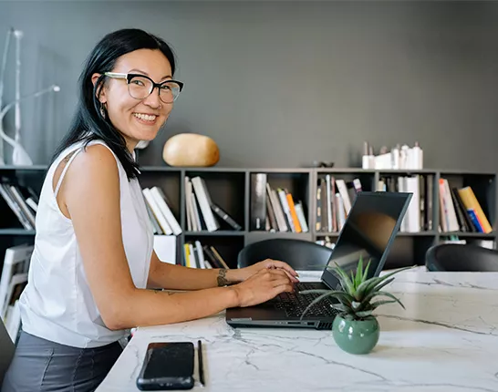 woman wearing glasses on computer in office
