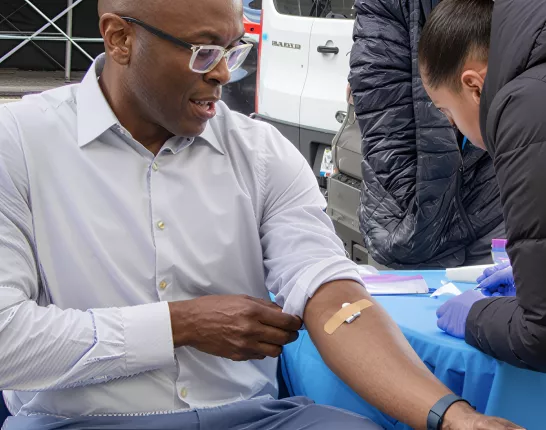 Man sitting at a table getting his blood drawn
