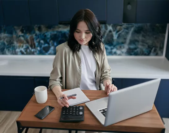 woman sitting at desk with computer and glasses