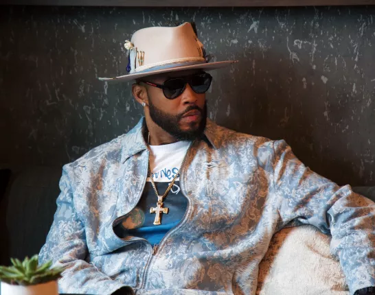 Montell Jordan in light blue jacket sitting