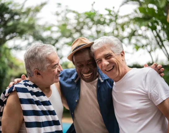 three men smiling outside