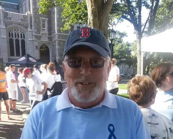A man wearing a Boston cap and a blue Warren's Warriors shirt